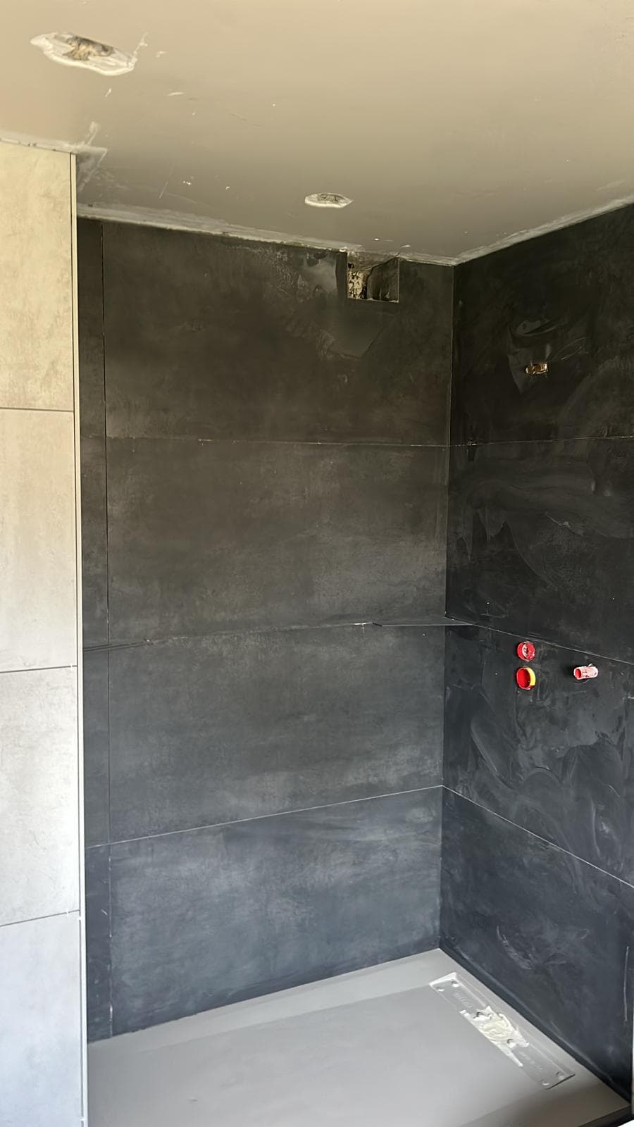 Salle de bain finie avec baignoire et carrelage clair